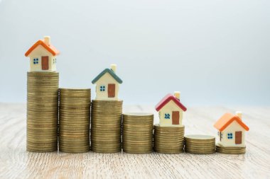 Bozuk para yığını ve oyuncak ev, konsept ev kredi, madeni para, iş, finans ve para. Başarılı finansal iş kavramları. Küçük modelli emlak projesi için tasarruf.