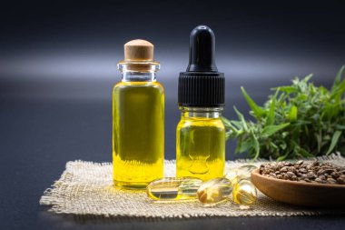Kenevir yağından elde edilen CBD kenevir yağı ve ilaç içeren cam şişe, kenevir yağı kavramının üzerine yerleştirilmiş. Alternatif tıp bitkileri doğadan elde edilir, yakın plan görüntü