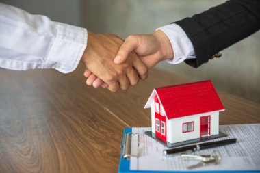İş adamları ve yatırımcılar ev ticaretinde. Güvenmek için el ele tutuşuyorlar. Ev satın alma sözleşmesi yapmak için el ele tutuşun. Emlak komisyoncuları ya da ajanslarla el ele tutuşun. Sözleşmenin tatmin edici olması için..