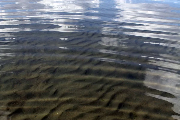 La arena en la playa bajo el agua, el lago de la playa desierta, el verano, la luz del sol en la arena —  Fotos de Stock