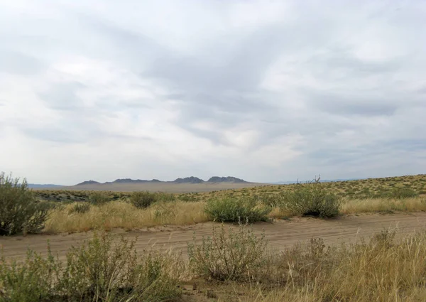 Beyaz bulutlar Sayan Dağları Sibirya Rusya ile mavi gökyüzü altında sarı çim ile geniş bozkır