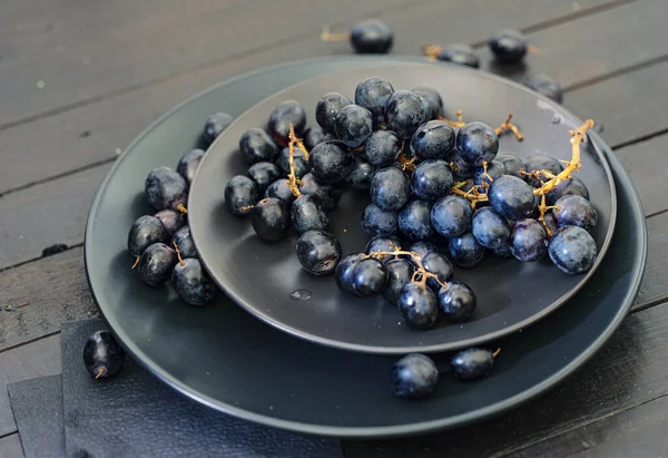 Closeup View Black Grapes Black Plates Wooden Table — Stock Photo, Image