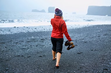 Kumsalda yürüyen bir kadın