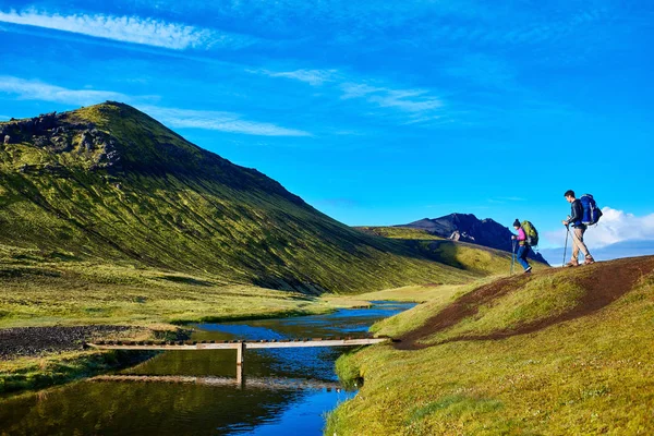 Excursionistas y puente sobre arroyo, trekking en Islandia —  Fotos de Stock