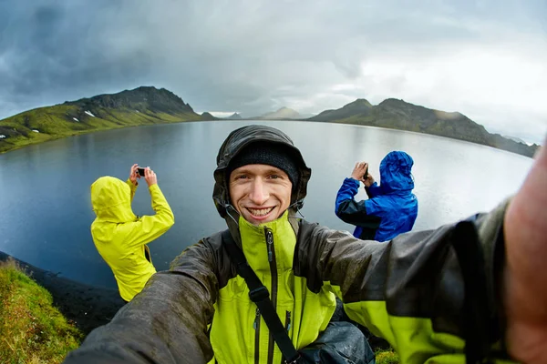 Excursionistas en la costa del lago con reflexión de montaña, Islandia — Foto de Stock