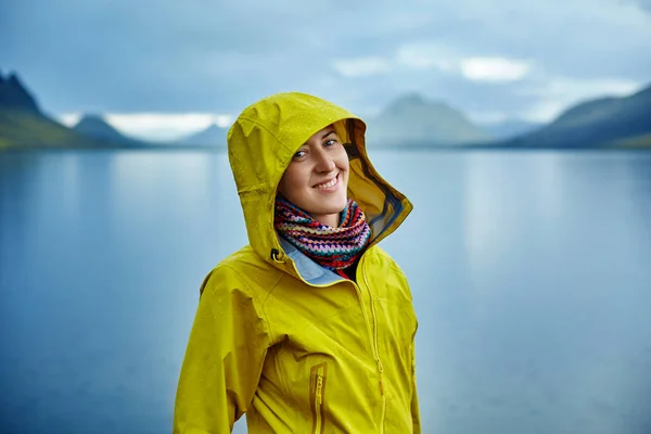 Femme sur la côte du lac avec reflet de montagne, Islande — Photo