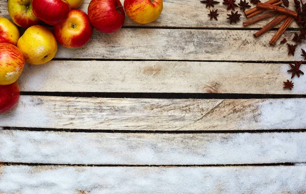 Punaisia ja keltaisia omenoita valkoisella puupöydällä — kuvapankkivalokuva