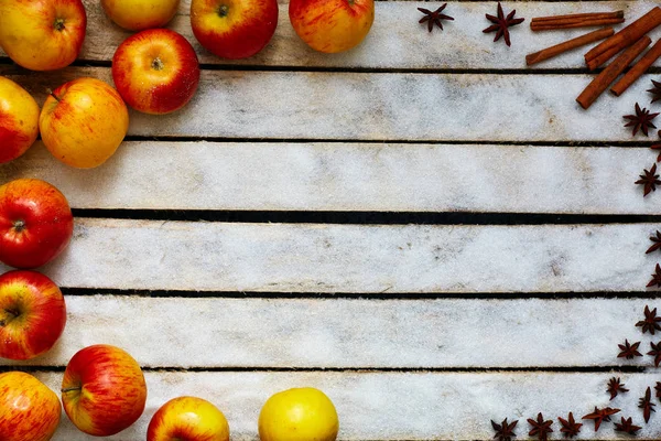 Красные и желтые яблоки на белом деревянном столе — стоковое фото