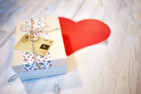 Geschenk doos en papieren hart over de houten tafel — Stockfoto