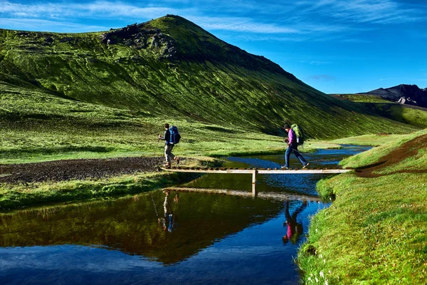 Excursionistas y puente sobre arroyo, trekking en Islandia —  Fotos de Stock