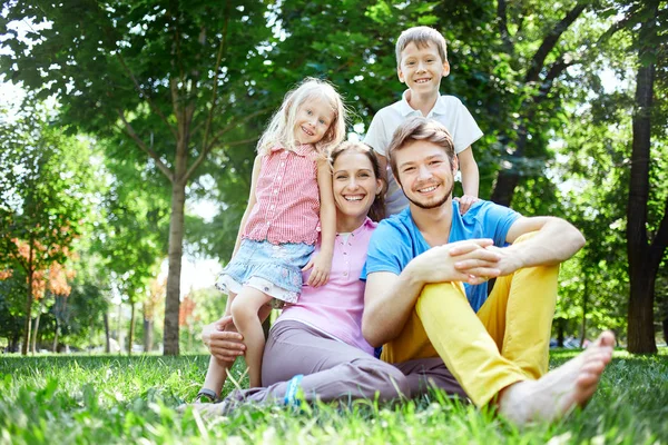 Family at noon in the park on the grass — Stock Photo, Image
