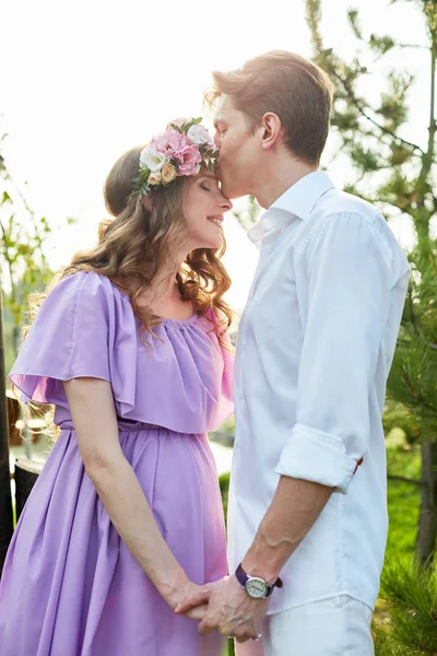 Pregnant woman and her husband walks in park at evening — Stock Photo, Image