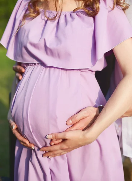 Pregnant woman and her husband walks in park at evening — Stock Photo, Image