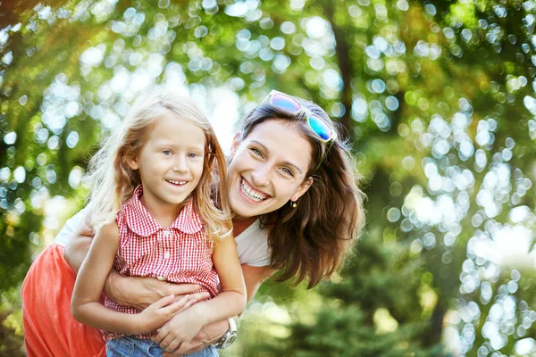 Happy woman and child in the blooming spring garden.Mothers day holiday concept — Stock Photo, Image