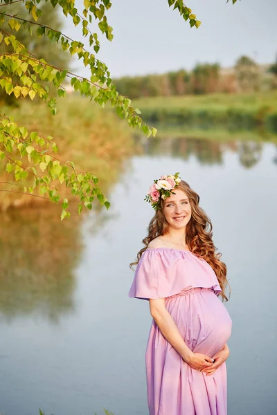 Pregnant woman walks in park at evening — Stock Photo, Image