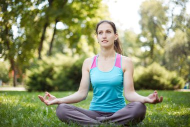 Mutlu kadın yoga yaparken egzersizleri, parkta meditasyon