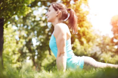 Mutlu kadın yoga yaparken egzersizleri, parkta meditasyon