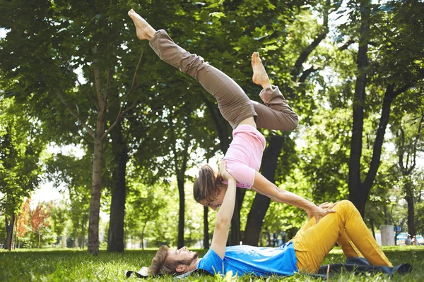 stock image Cute couple doing acro yoga in the park on a sunny day