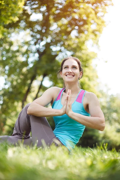 Щаслива жінка займається вправами йоги, медитує в парку — стокове фото