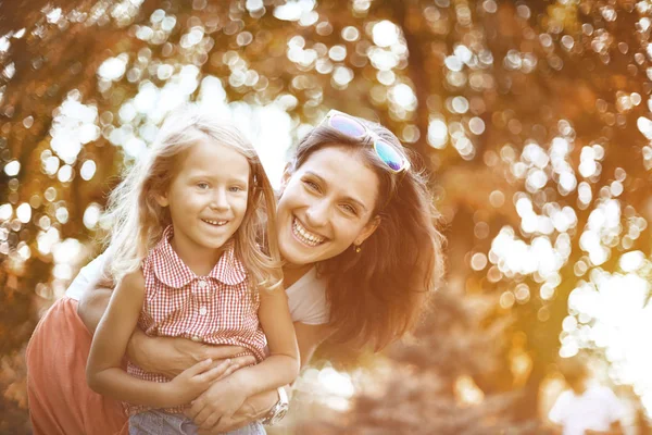 Mujer feliz y niño en el floreciente jardín de primavera.Concepto de vacaciones del día de las madres — Foto de Stock