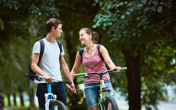 Ungdomar, par med cyklar i parken — Stockfoto