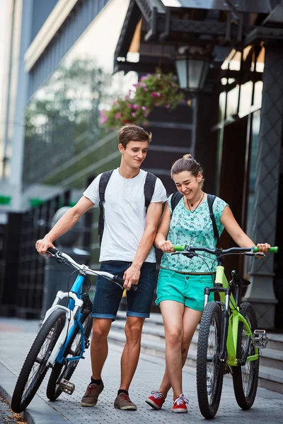 Giovani, coppia con biciclette in strada — Foto Stock