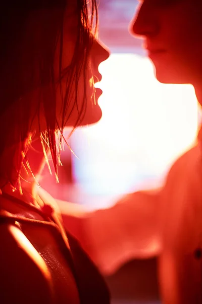 Les jeunes embrassant dans l'appartement le soir dans les rayons du coucher du soleil — Photo