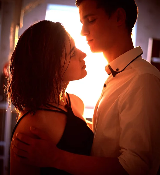 Young people hugging in the apartment in the evening in the rays of the sunset — Stock Photo, Image