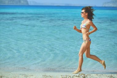Kumsalda koşan kadın.