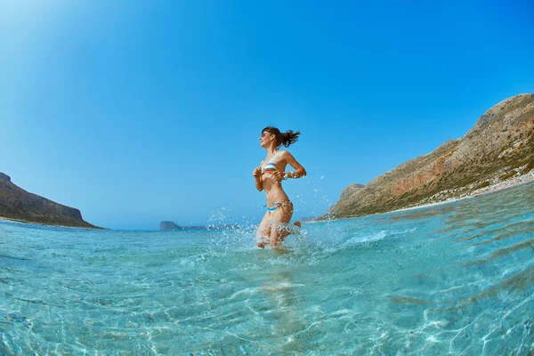 Kvinne løper på stranden – stockfoto