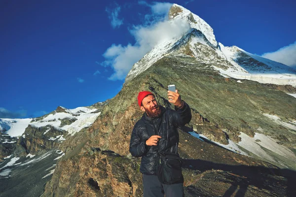 Caminhante fazendo selfie no topo de uma passagem no fundo de montagem Matterhorn — Fotografia de Stock