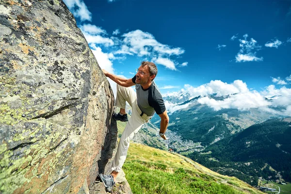 Climber climbing up a cliff — Stock Photo, Image