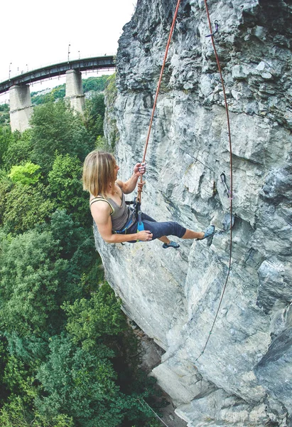 Donna arrampicatrice si arrampica sulla scogliera — Foto Stock