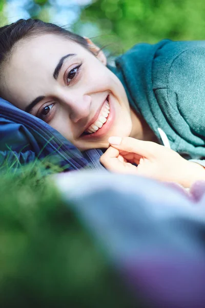 Retrato de cerca de una hermosa mujer feliz tendida en la hierba en el parque —  Fotos de Stock