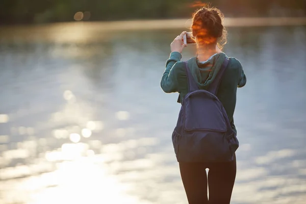 Retrato de hermosa chica feliz en ropa deportiva en la orilla de un lago o mar —  Fotos de Stock