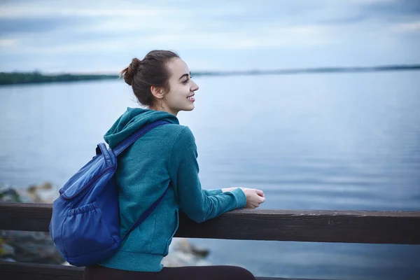 Ritratto di bella ragazza felice in abbigliamento sportivo sulla riva di un lago o mare — Foto Stock