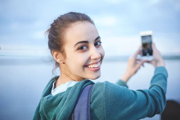 Portret pięknej dziewczyny szczęśliwy w sportowej na brzegu jeziora lub morza — Zdjęcie stockowe