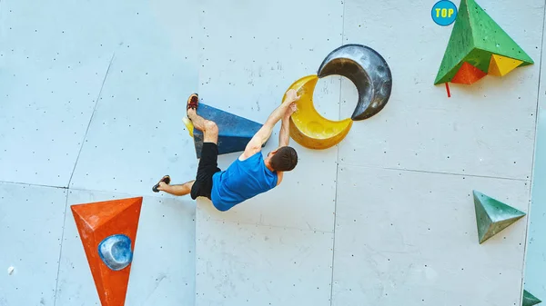 Escalador hombre sube un problema de bouldering en gimnasio de escalada — Foto de Stock