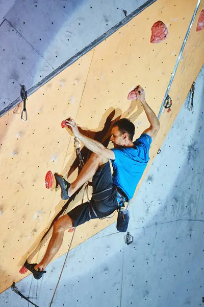 Hombre escalador sube un con cuerda en el gimnasio de escalada — Foto de Stock