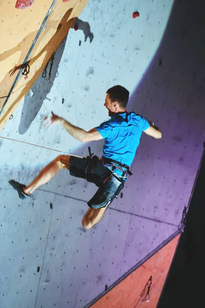 Hombre escalador sube un con cuerda en la escalada gimnasio y la caída — Foto de Stock