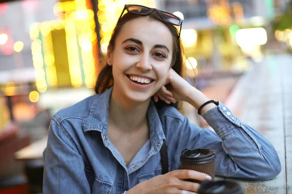 The girl is drinking coffee in town and laughs — Stock Photo, Image
