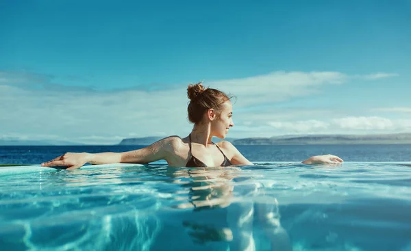 Nainen rentoutuu uima-altaassa ulkona — kuvapankkivalokuva