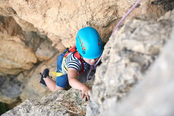 A little boy climbs on rock — Stock Photo, Image