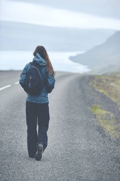 Une touriste sur la route vide du fjord en Islande — Photo