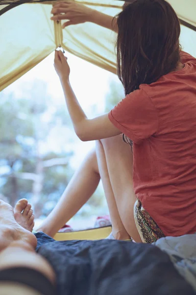 Morming näkymä sisältä teltta metsässä ja nuori nainen — kuvapankkivalokuva