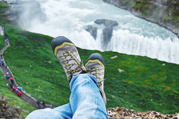 Mans pieds en bottes sur le fond de cascade en Islande — Photo