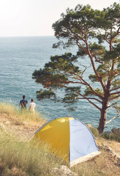 Gula tält och par stående på havsstranden — Stockfoto