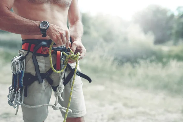 Een man Knots een knoop op een klimmen harness — Stockfoto