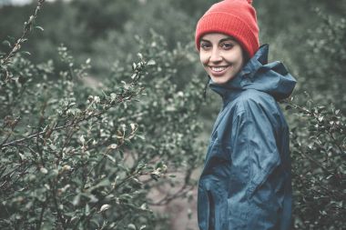 ağaçlar ve çalılar ıslak yağmurlu havalarda arasında bir kadın turist yürür