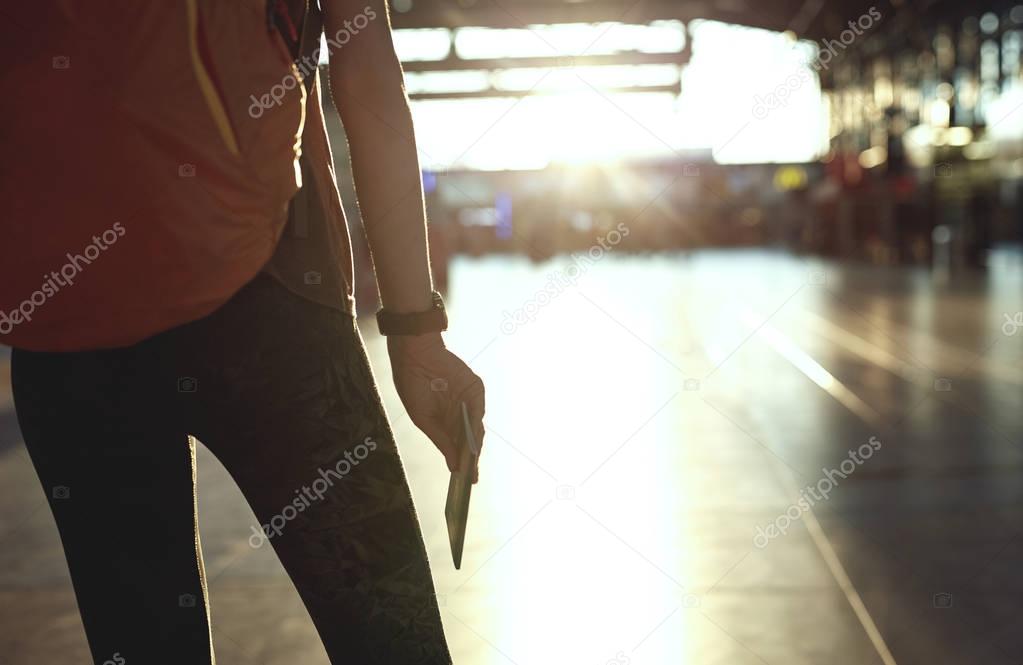 woman in the hall of the airport terminal with a passport and boarding pass